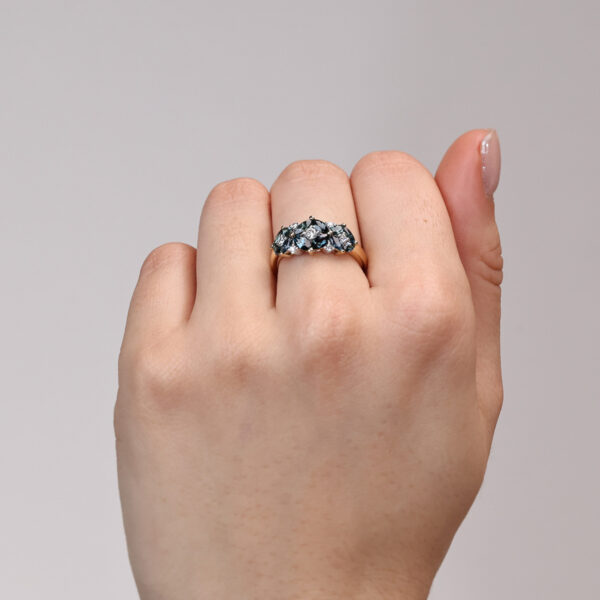 Primrose ring with floral cluster of marquise cut blue sapphires and white diamonds in 18k yellow and white gold